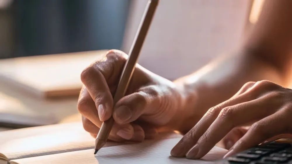 Mains préparant un calcul de chemin de vie dans un carnet